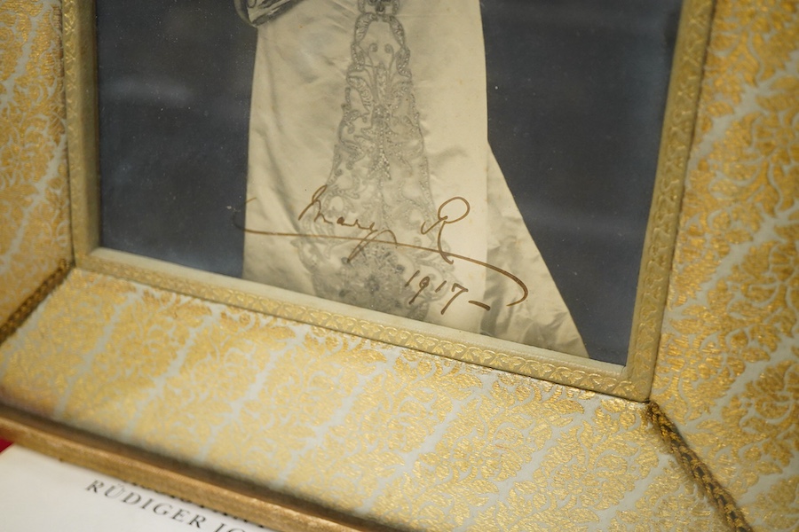 A framed photograph of Queen Mary, signed by the Queen across the bottom of the image and dated 1917, contained within a gilt padded mount and leather frame, overall dimensions 44 x 33cm